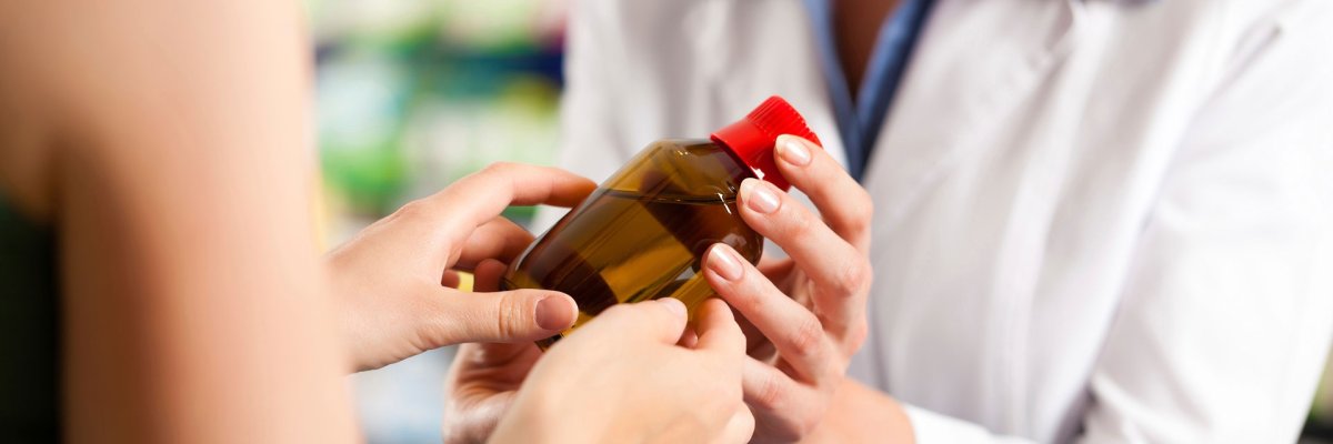 Zwei Hände halten ein braunes Packmittelgefäß mit roten Deckel in der Hand.