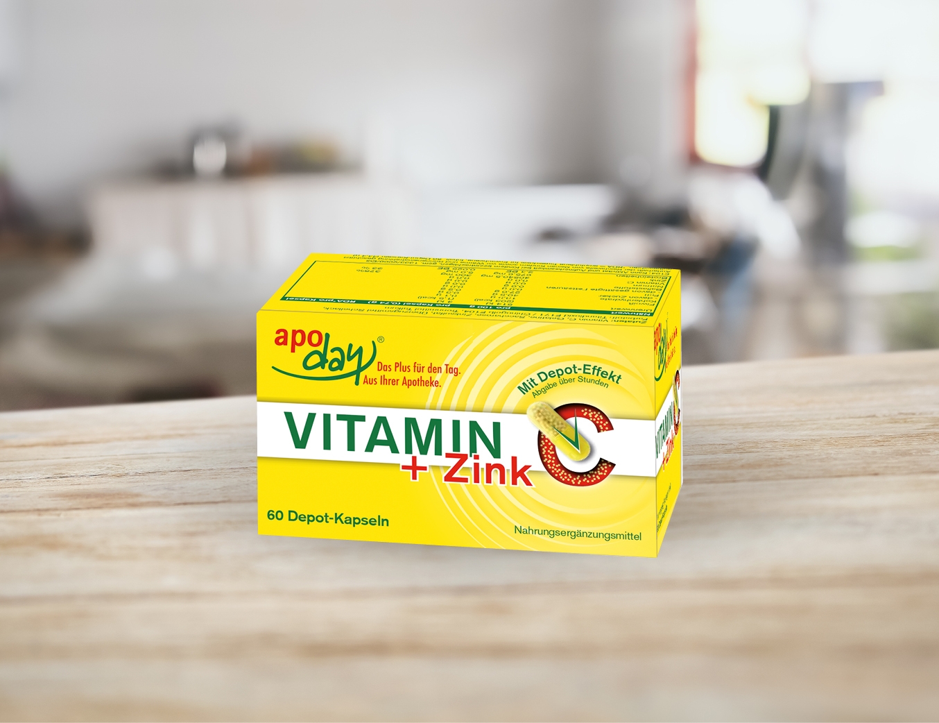 apoday Vitamin + Zink. Gelbe Packung auf einem Tisch stehend.