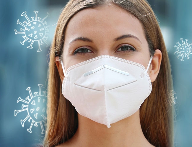 FFP2 Maske. Eine Frau mit dunklen Haaren trägt eine FFP2 Maske. Sie ist auf einem blauen Hintergrund mit Eiskristallen dargestellt