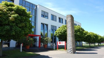 Firmengebäude der WEPA Apothekenbedarf mit einem Schild auf welchem das Logo WEPA die Apothekenmarke in rot abgebildet ist