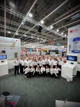 Das gesamte Messeteam der WEPA in weißem Hemd auf dem Messestand auf der Expopharm