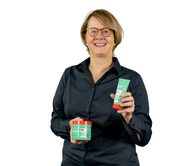 Claudia Spitzhorn, Teamleiterin ERP, hält ihr Lieblingsprodukt Pferdesalbe in die Kamera