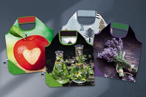Tüten mit individuellen Auftrag. Auf dem Bild sehen Sie vier Beispieltüten mit einem Apfelmuster, Blumen-, Tannen-und Lavendelmuster.